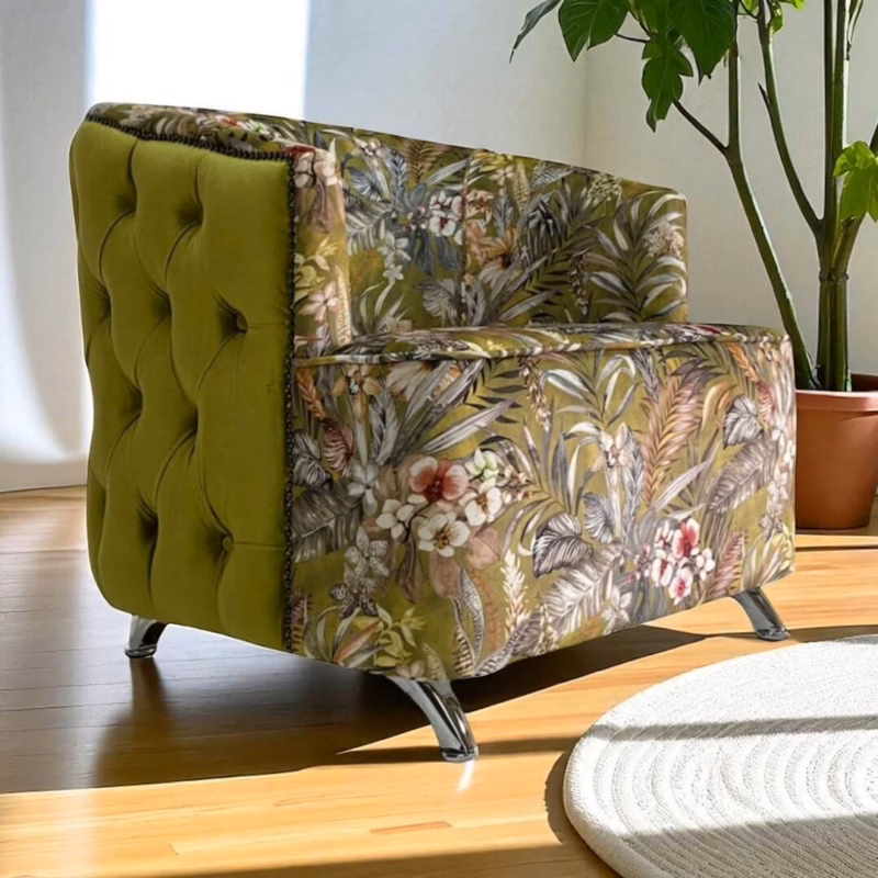 Side view of a green velvet and floral occasional chair with tufted back and chrome legs