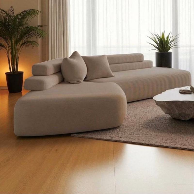 Modern bean-shaped couch in neutral tones with layered backrest, perfect for minimalist interiors.